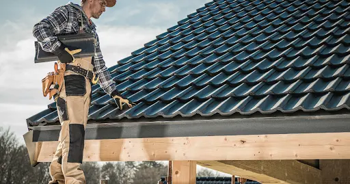 Inspecting broken tiles on a tile roof